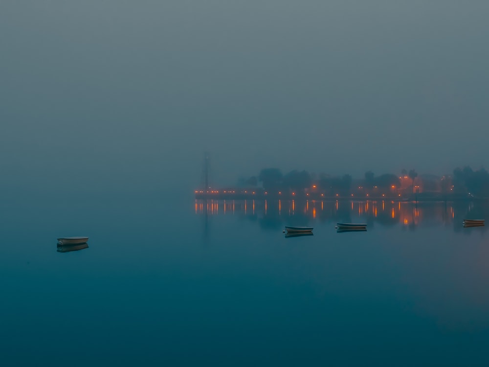 silhouette of bridge over body of water during night time