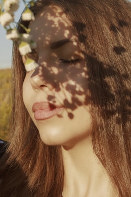 A serene portrait of a therapist smiling gently in a sunlit room filled with plants.