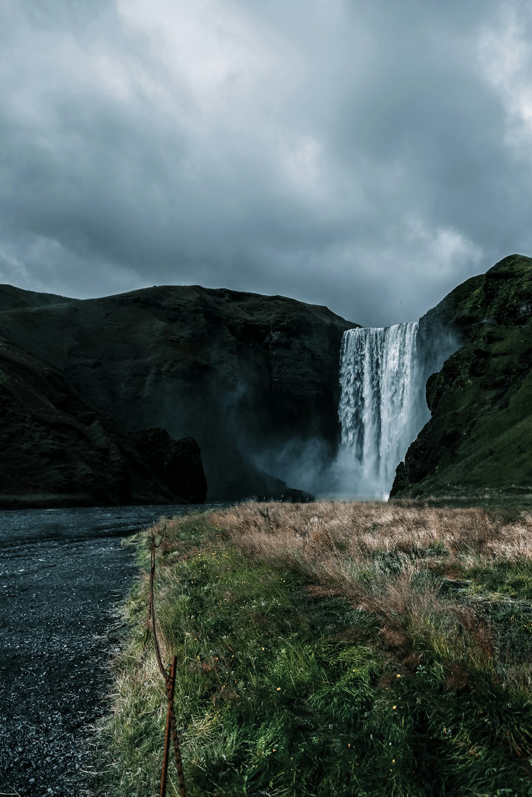 waterfalls near green grass field under white cloudy sky during daytime