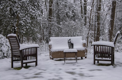 brown wooden bench covered with snow