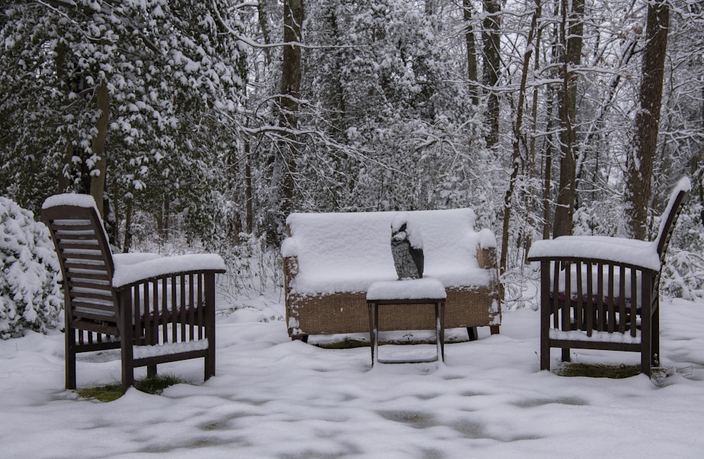 Banco de madera marrón cubierto de nieve