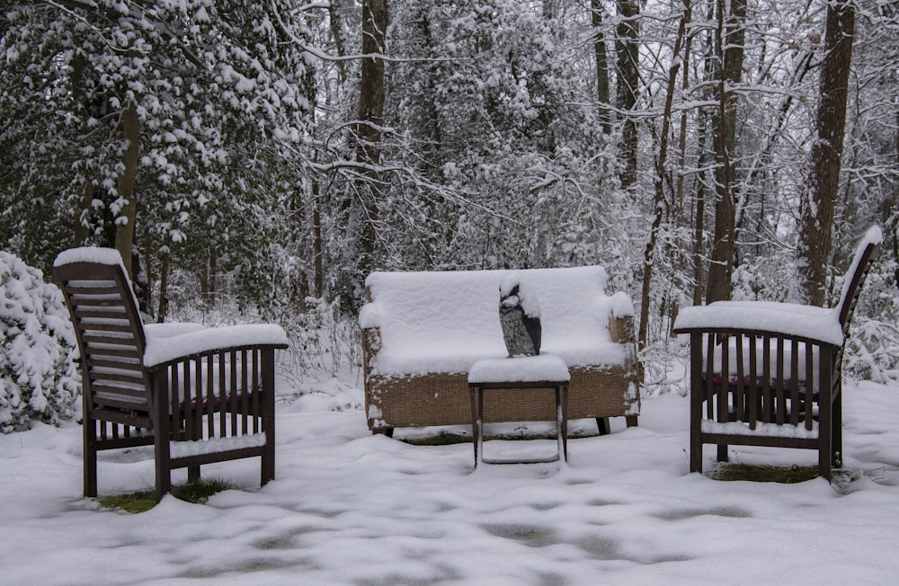 雪に覆われた茶色の木製ベンチ