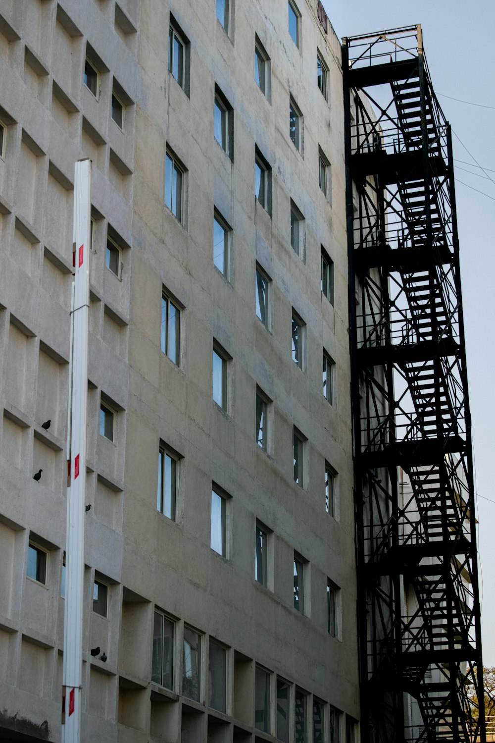 white concrete building with red metal ladder