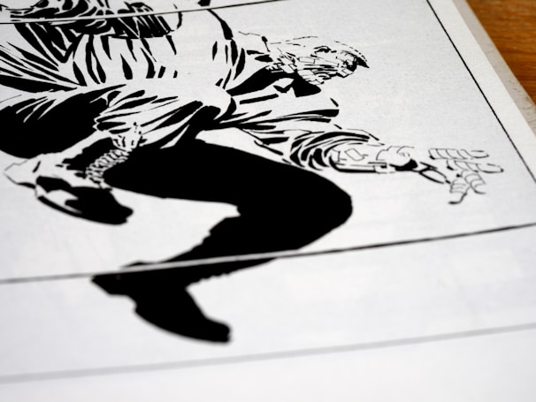 A stylized, high-contrast black and white drawing of a crouching figure with exaggerated features. The illustration appears to be from a comic book, depicting dynamic motion through bold lines and angular shapes. The figure's hand and boot are prominently detailed, capturing a sense of action.