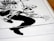 A stylized, high-contrast black and white drawing of a crouching figure with exaggerated features. The illustration appears to be from a comic book, depicting dynamic motion through bold lines and angular shapes. The figure's hand and boot are prominently detailed, capturing a sense of action.