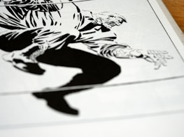 A black and white graphic illustration featuring a dynamic composition of a person in motion. The character is depicted with bold lines and exaggerated features, capturing a sense of movement and tension.