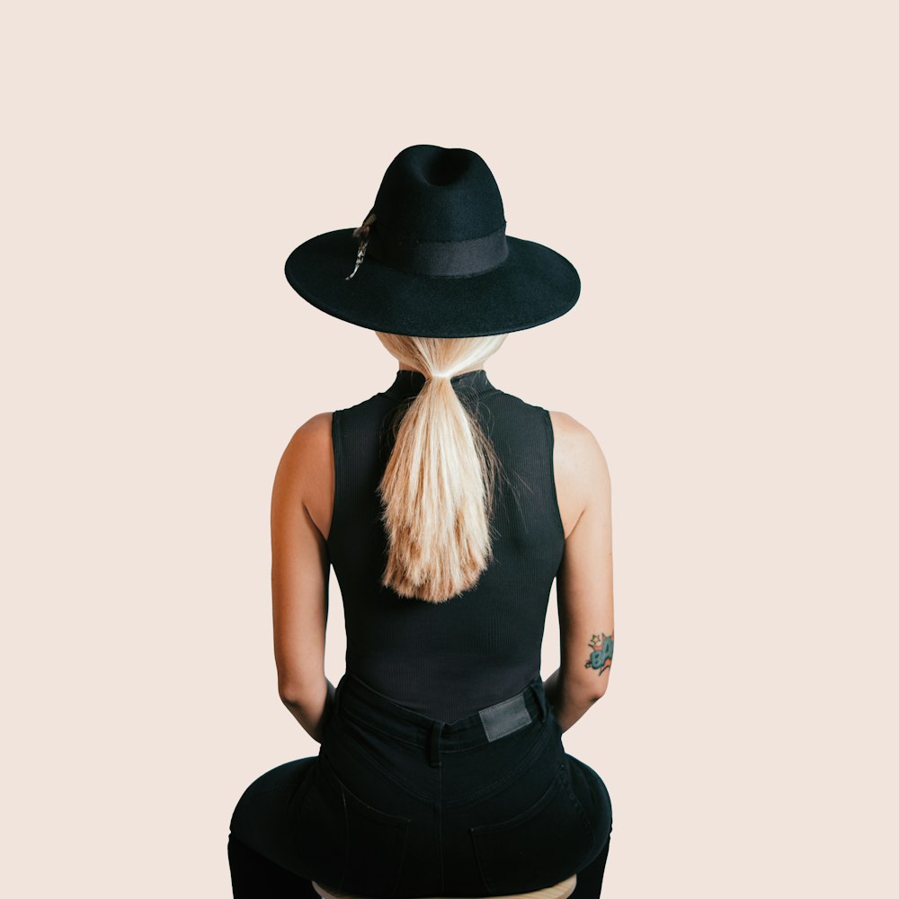 Mujer con camiseta sin mangas negra con sombrero negro
