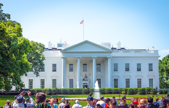 people in front of white and green concrete building during daytime