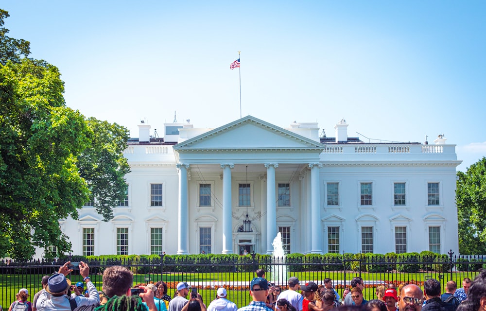 people in front of white and green concrete building during daytime