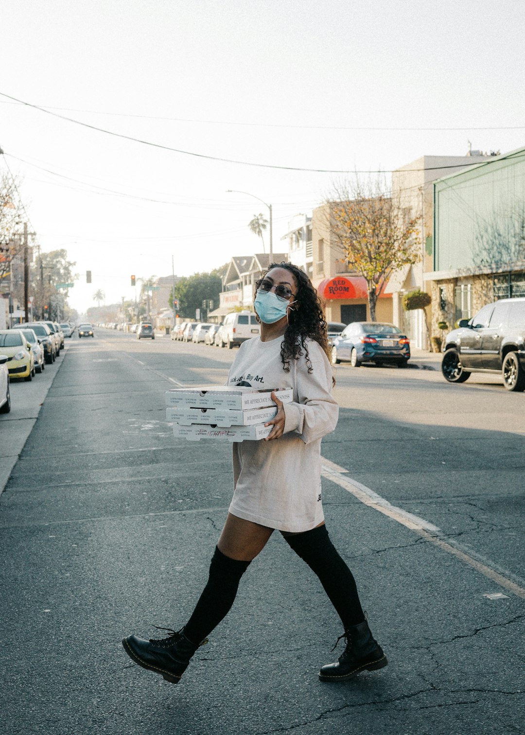 woman in white coat standing on road during daytime