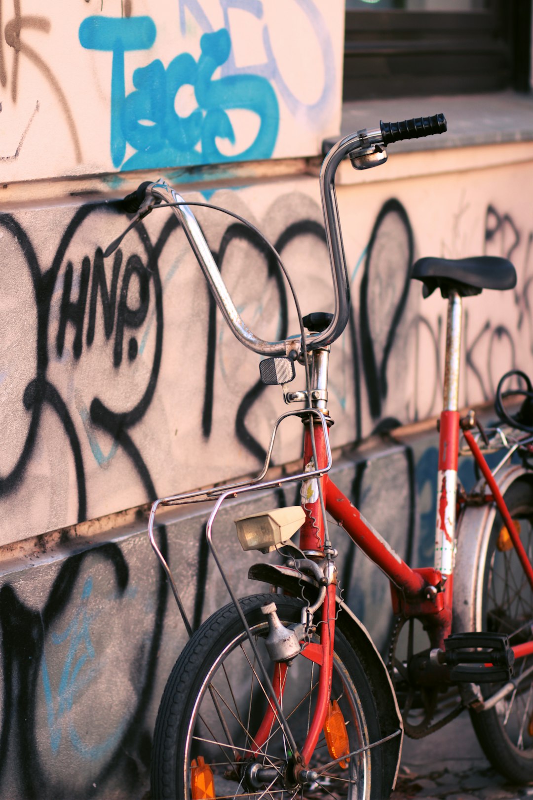 red and black bicycle leaning on wall