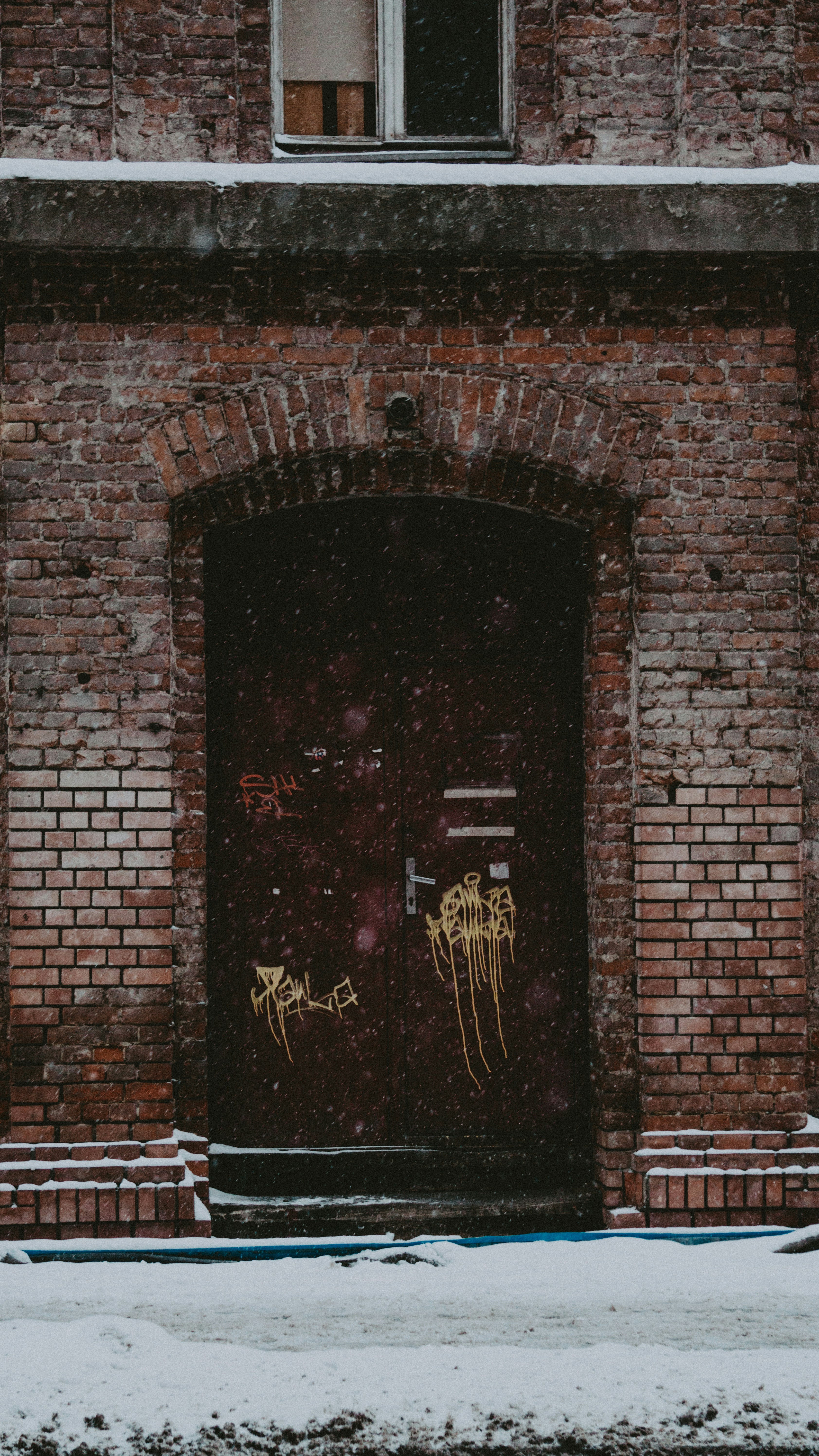 brown wooden door on brick wall