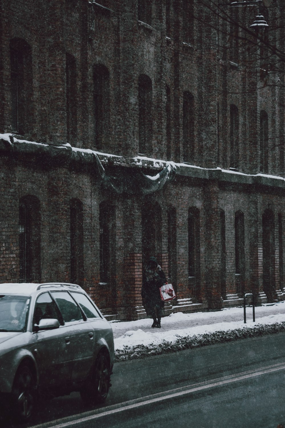 man in black jacket standing beside white suv during daytime