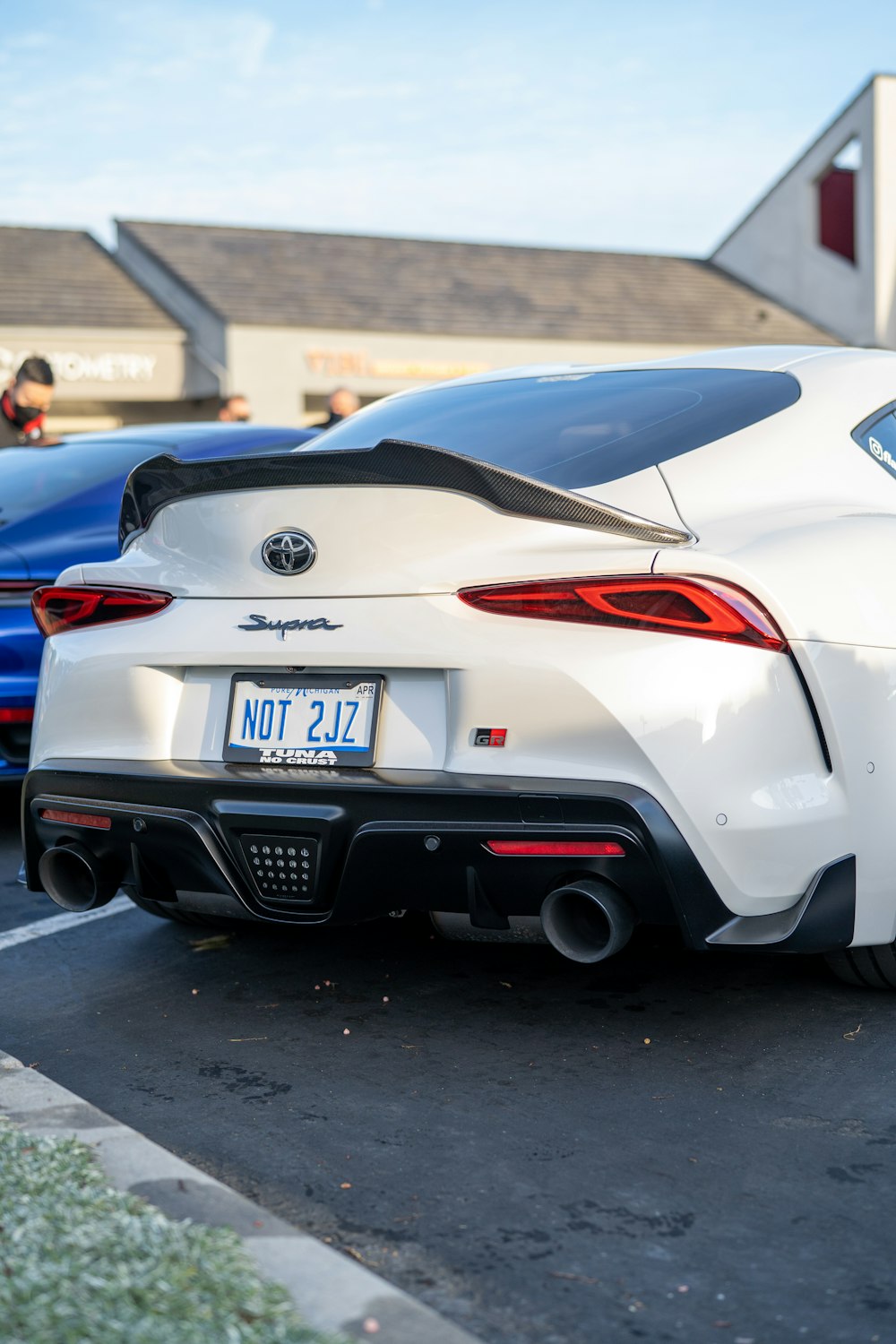 a white sports car parked in a parking lot