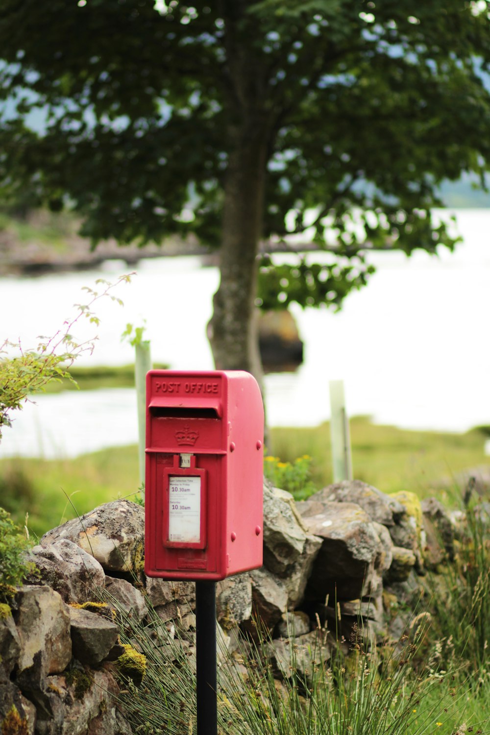 red mail box on brown rock during daytime
