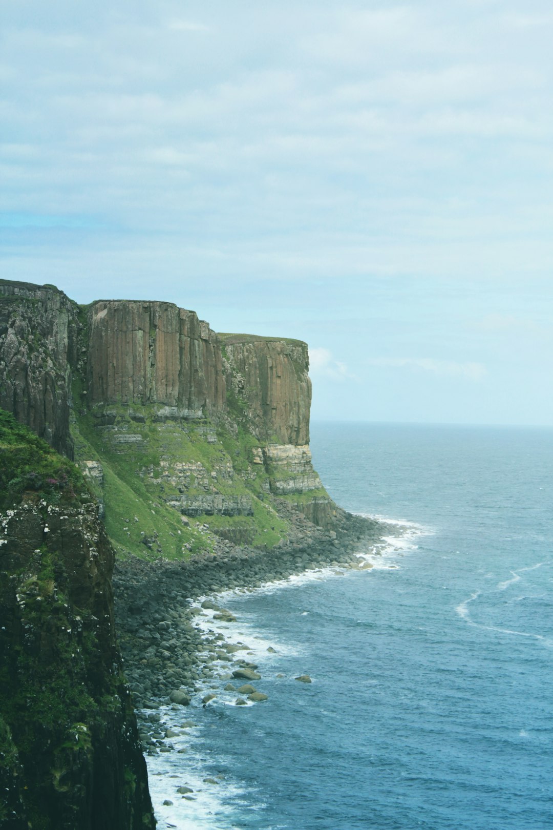 green and brown mountain beside body of water during daytime