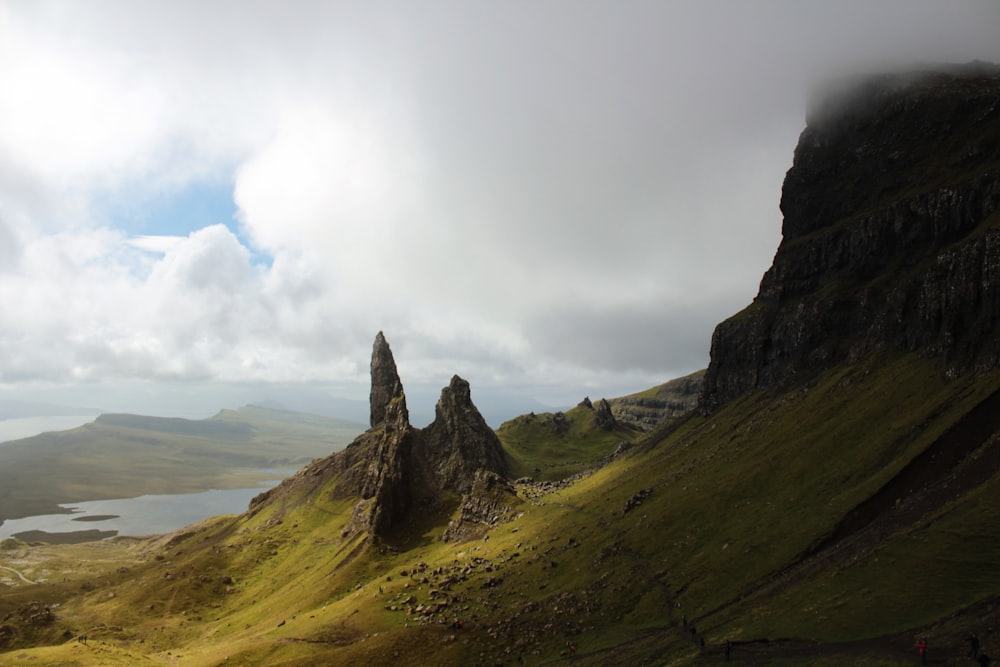 green and brown mountain under white clouds during daytime