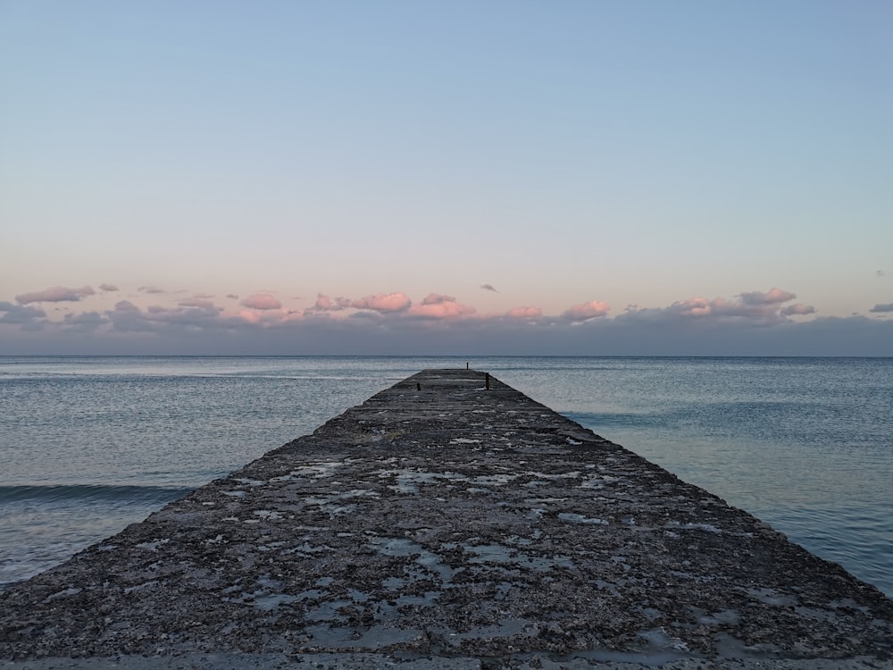 gray concrete dock on sea during daytime