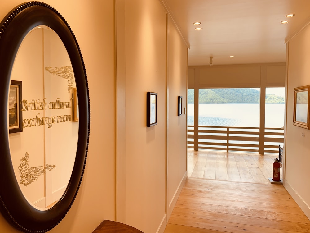 brown wooden parquet floor with round brown wooden framed wall mirror
