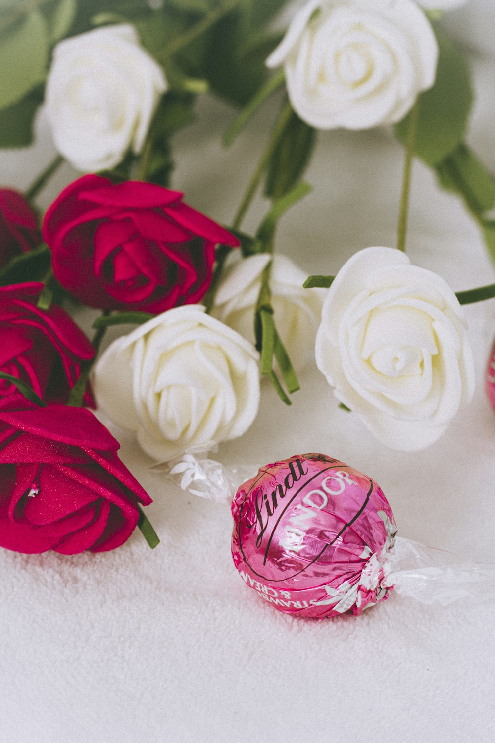 red and white roses on white textile