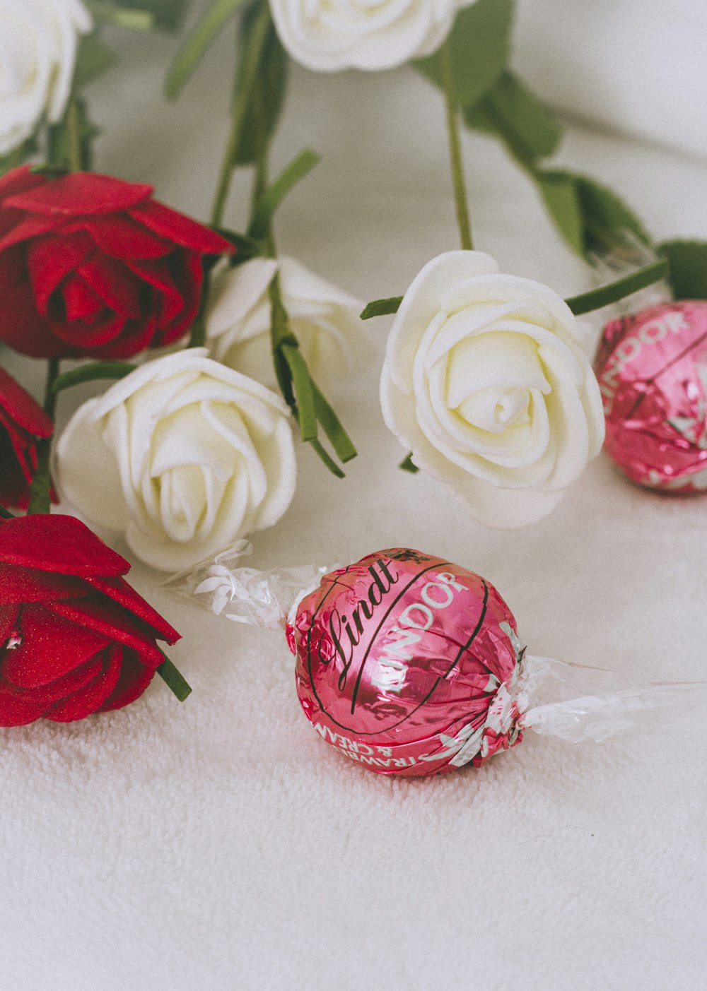 red and white roses on white textile