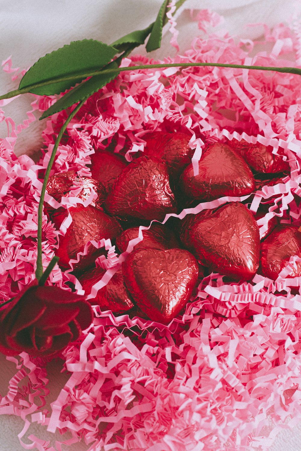 rote und weiße Blütenblätter auf weißem und rosa Blumentextil