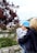 woman in black jacket and blue cap standing near green plants during daytime