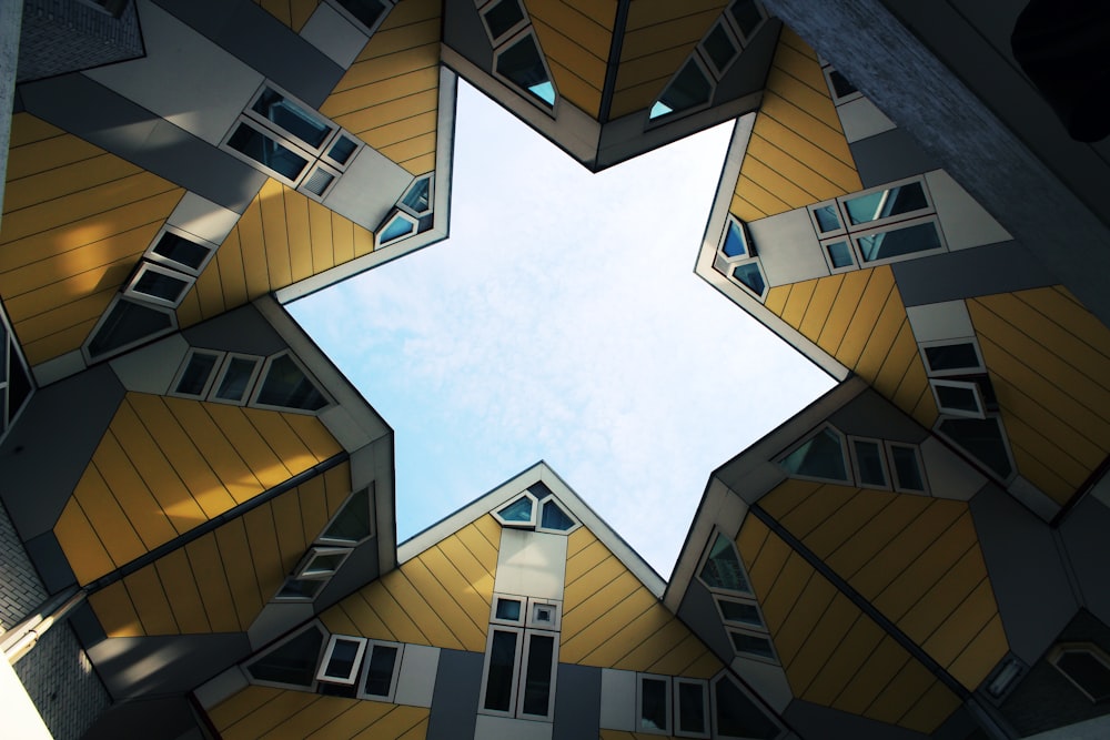 low angle photography of brown and white concrete building under white clouds and blue sky during