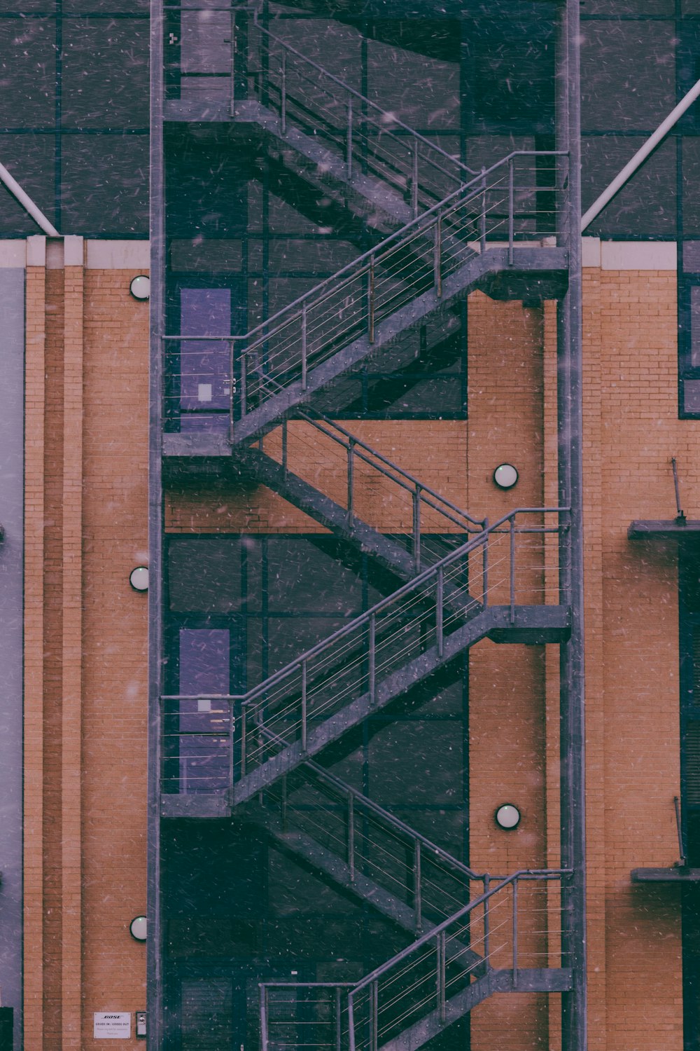 black metal ladder on brown brick wall