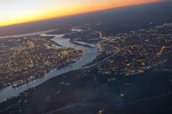 Aerial view of interconnected water pipelines running beneath a bustling cityscape at sunset.