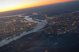 Aerial view of interconnected water pipelines running beneath a bustling cityscape at sunset.