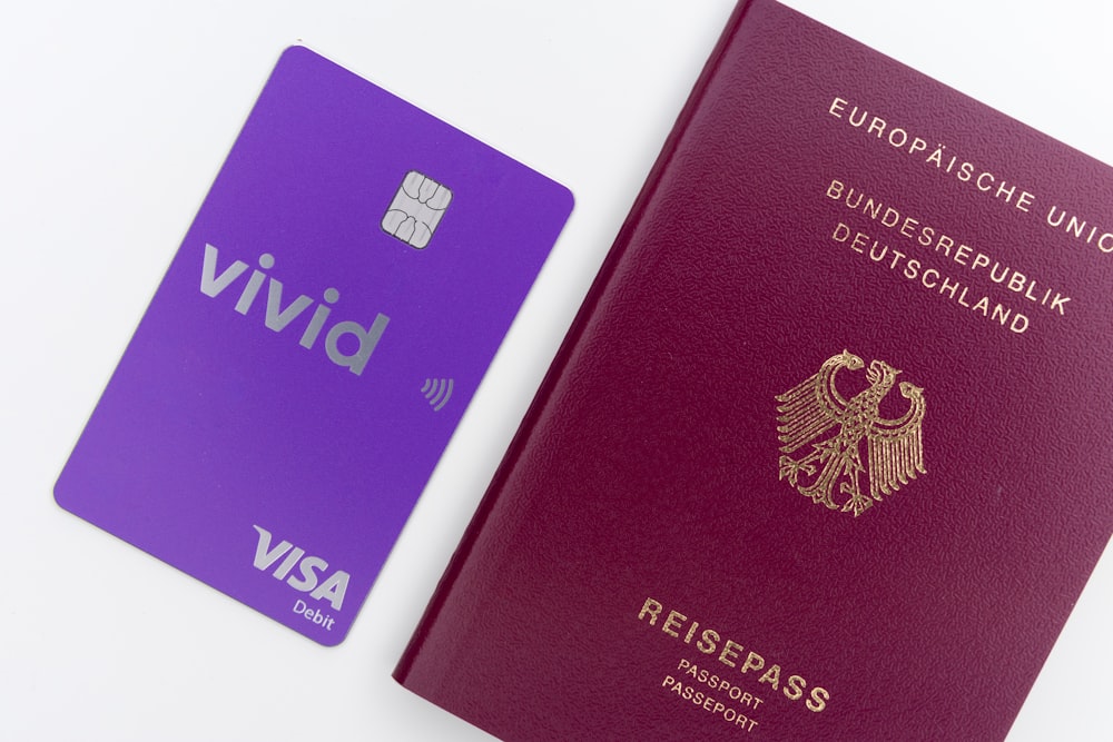 purple and gold passport on white surface