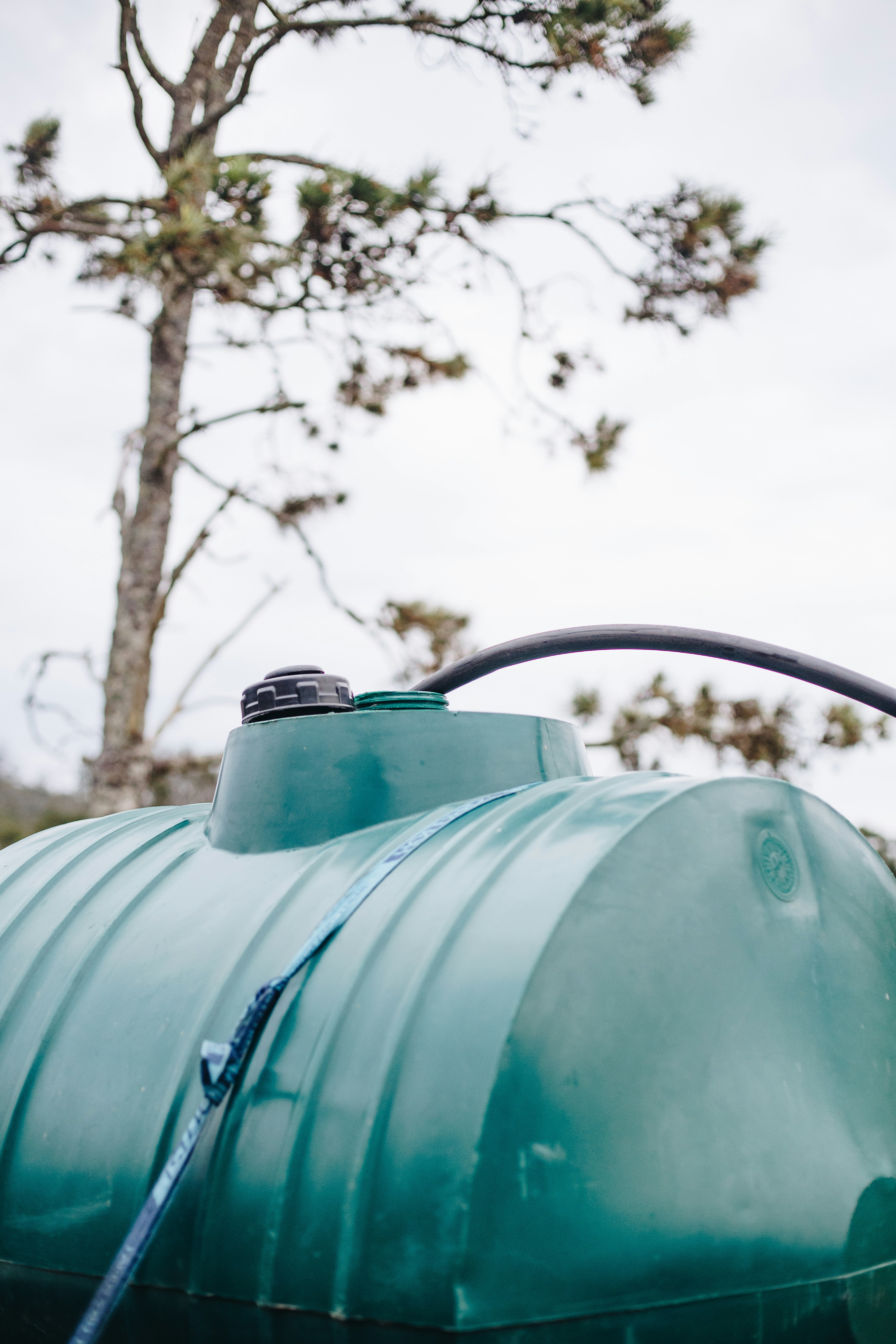 blue water tank on green grass field during daytime