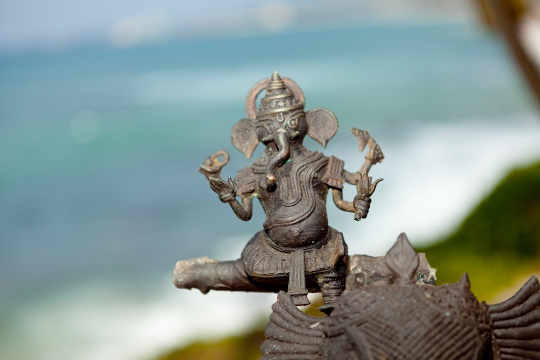 gold human figurine on brown wooden surface