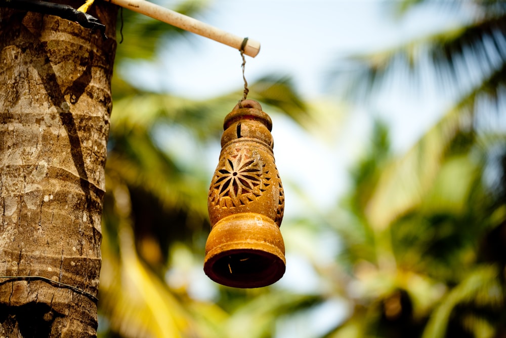 campana marrón colgada en un palo de madera marrón