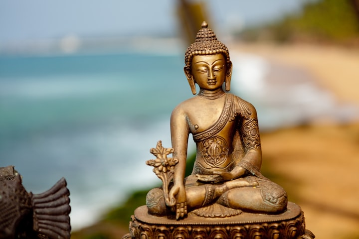 A figurine of Buddha by the shores of the sea