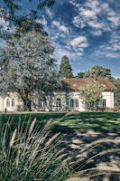 A charming residential building with freshly painted exterior and manicured landscaping under a clear blue sky.