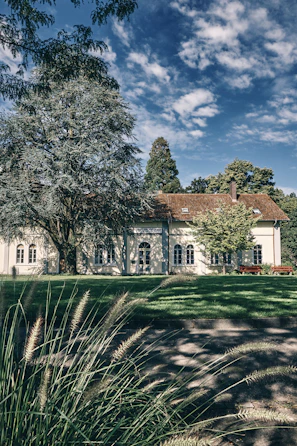 A charming residential building with freshly painted exterior and manicured landscaping under a clear blue sky.