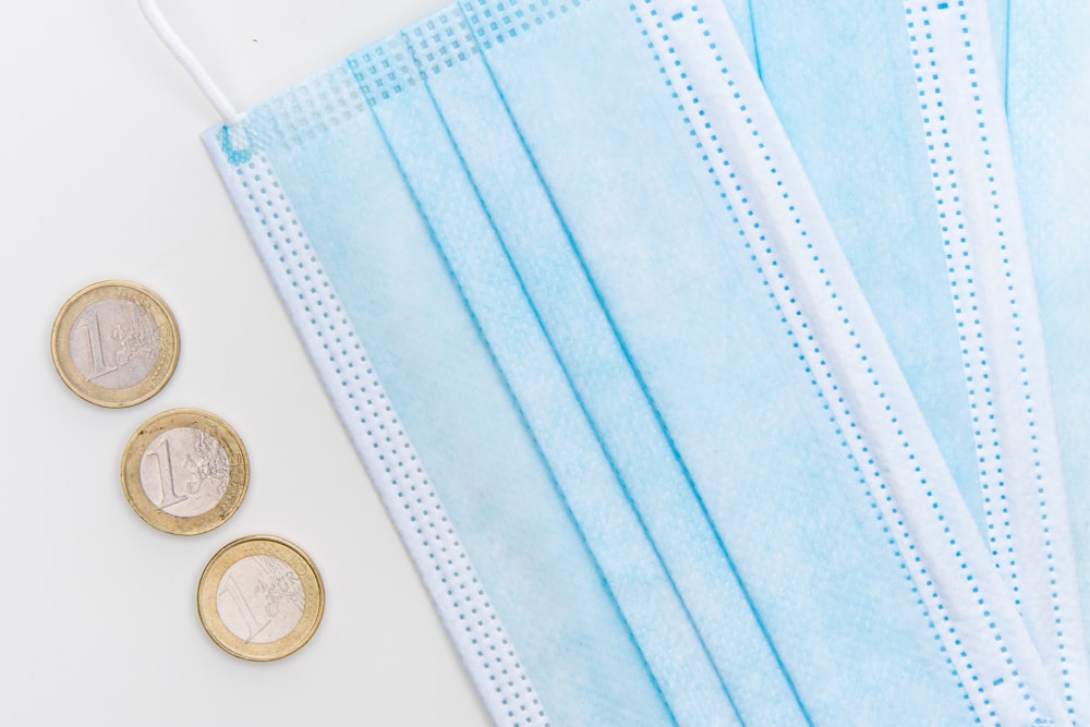 silver round coins on white textile