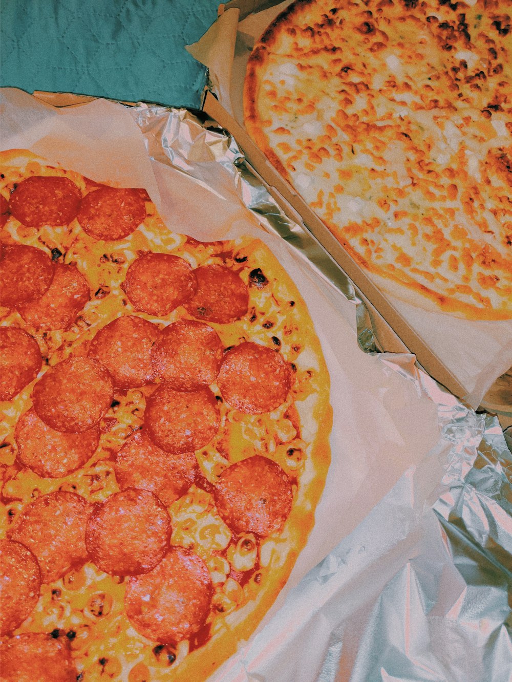 a couple of pizzas sitting on top of aluminum foil