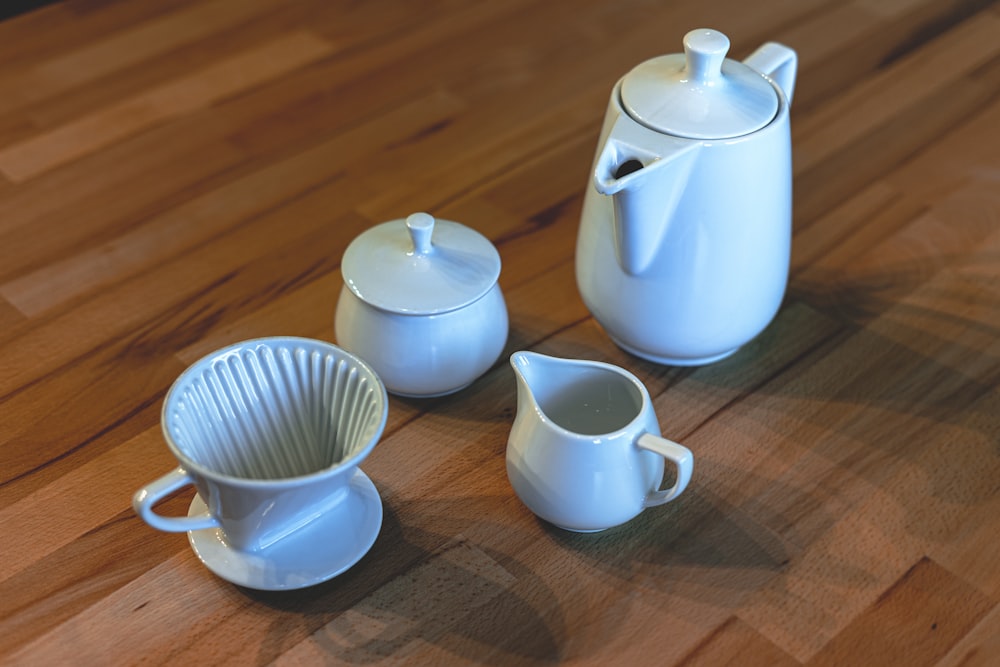 white ceramic teapot and mugs on brown wooden table