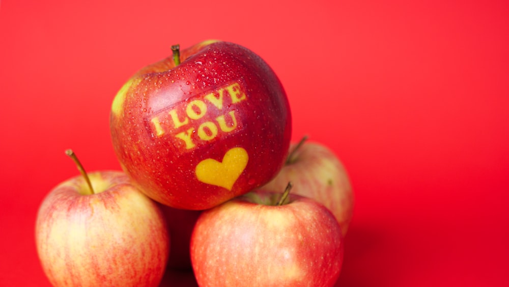 manzanas rojas y amarillas sobre superficie rosada