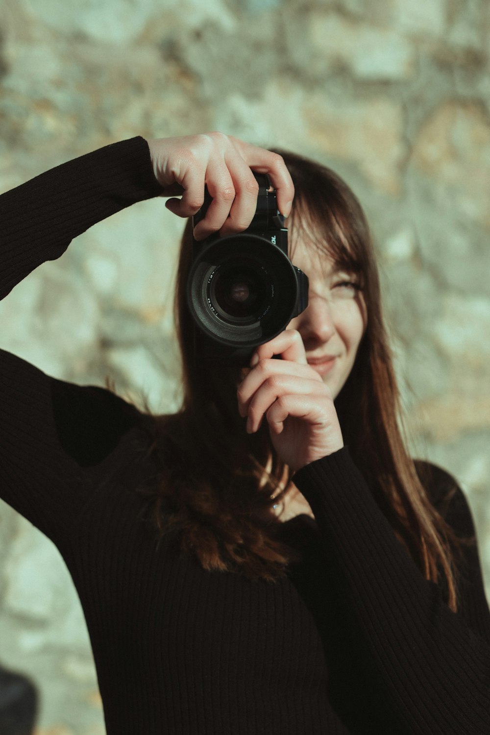 woman in black long sleeve shirt holding black camera