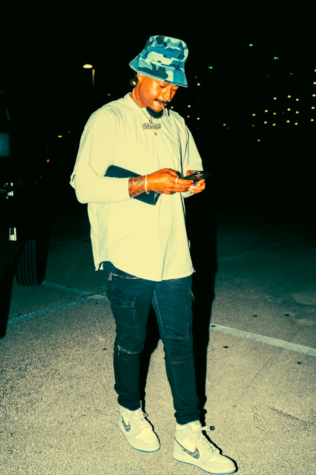 man in white dress shirt and blue denim jeans standing on gray pavement