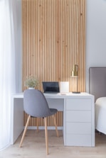 white wooden desk with gray chair