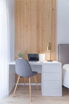 white wooden desk with gray chair