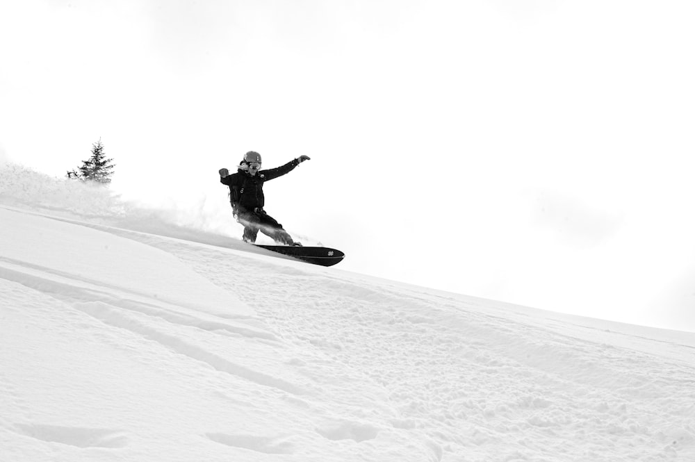 man in black jacket riding on snowboard