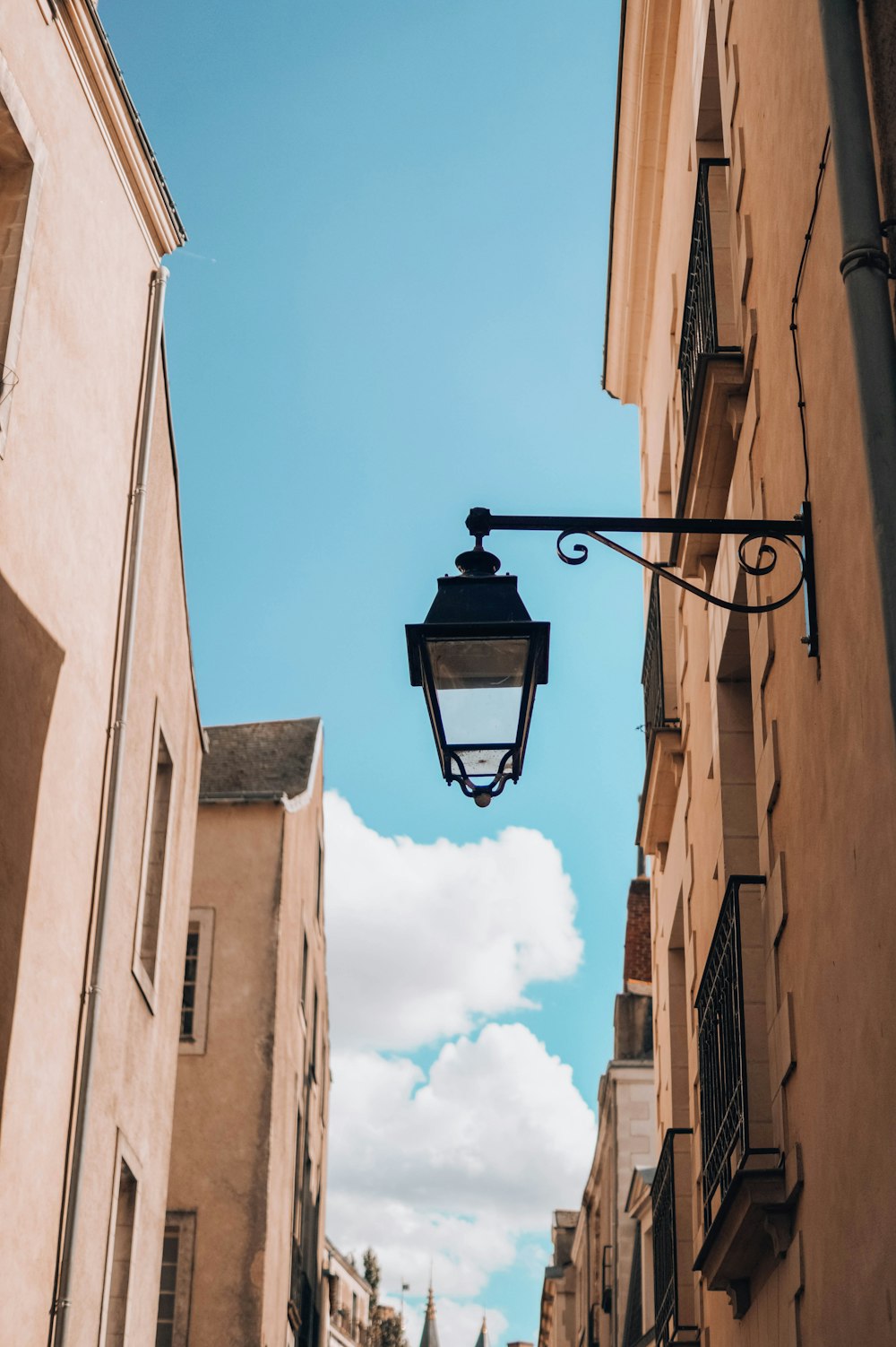 black street light under white clouds and blue sky during daytime