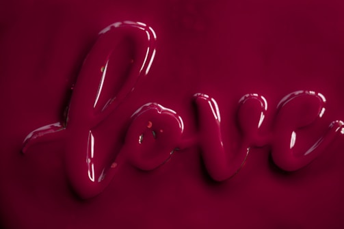 Glossy, dark pink letters forming the word 'love' on a matching background.