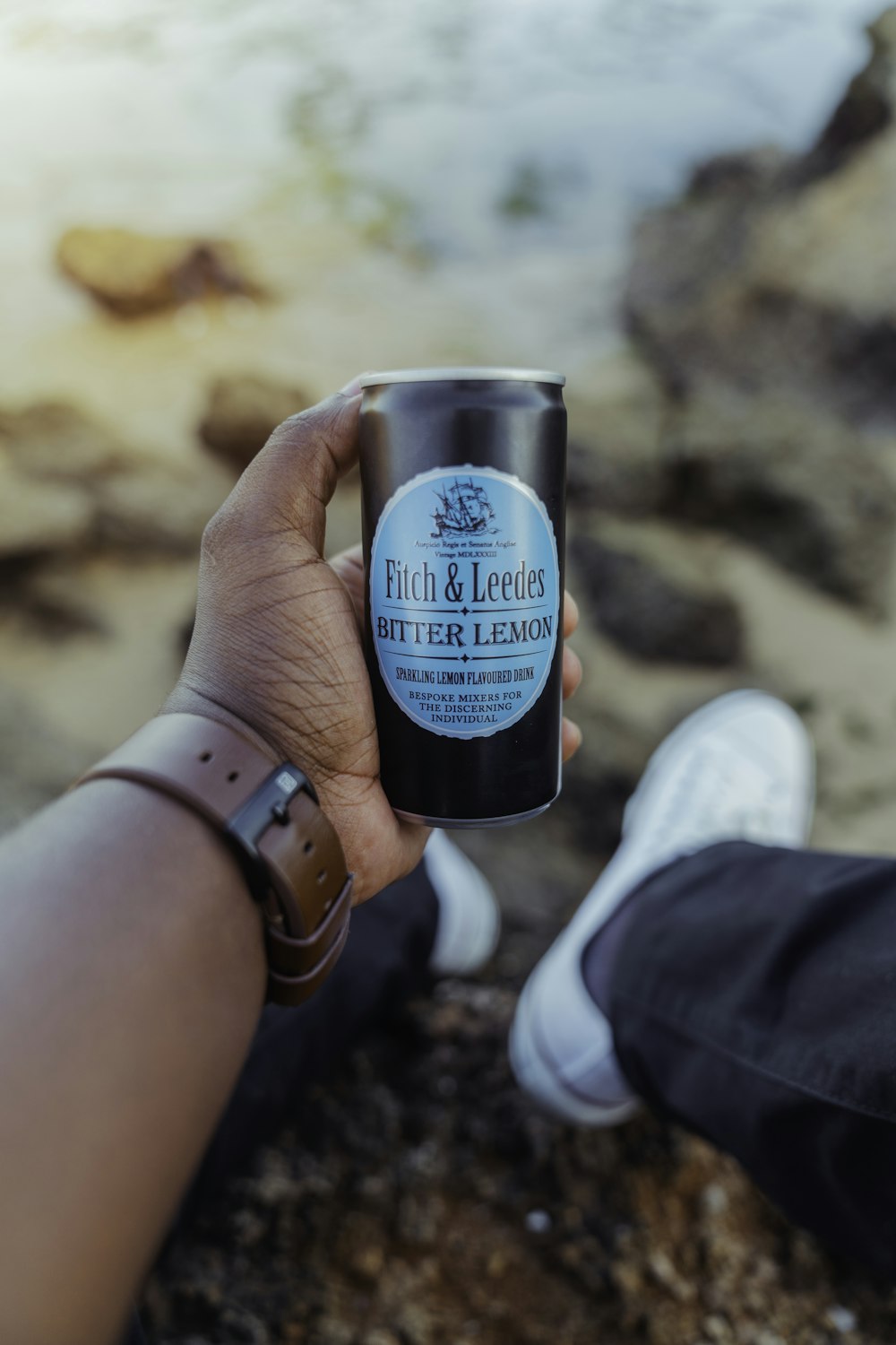 person holding blue and black the body shop bottle